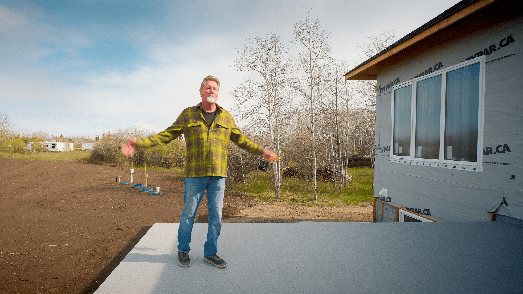 Builder standing on a deck with his arms wide open