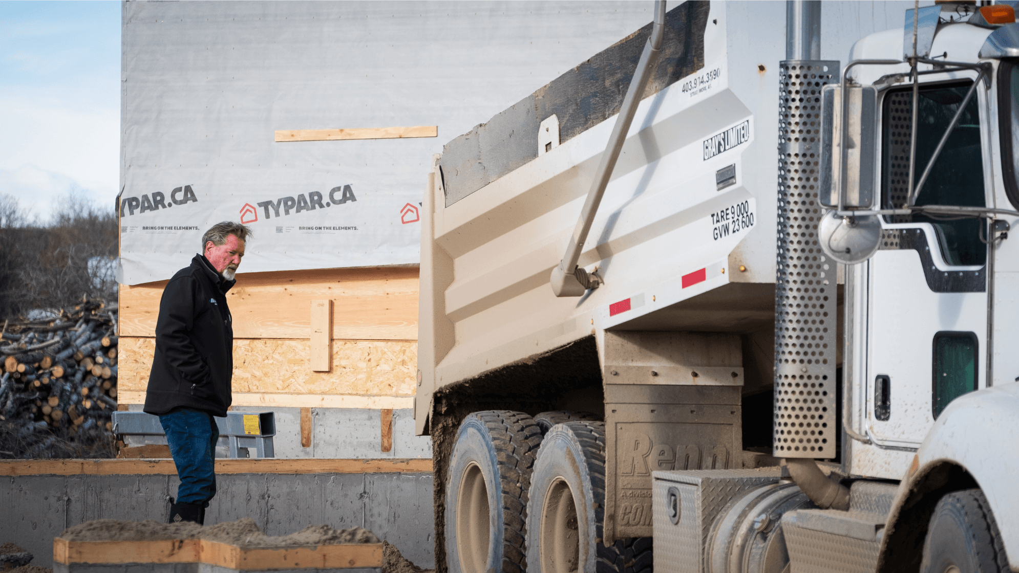 Home builder standing at the back of a truck ready to unload