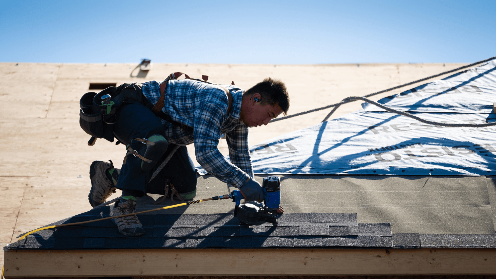 Roofer working on adding the shingle to a new roof